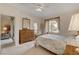Comfortable bedroom with a bed, dresser, ceiling fan, and a sitting area viewed through open doorway at 908 Domnus Ln # 203, Las Vegas, NV 89144