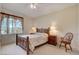 Bedroom features a decorative bed, ceiling fan, and a wooden chair, all bathed in natural light at 908 Domnus Ln # 203, Las Vegas, NV 89144