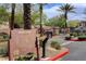 Community entrance featuring a directory sign, gated access, desert landscaping, and palm trees at 908 Domnus Ln # 203, Las Vegas, NV 89144