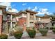 Inviting exterior showcasing a well-maintained two-story condo with stairs, landscaped bushes, and neutral paint colors at 908 Domnus Ln # 203, Las Vegas, NV 89144