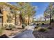 Well-maintained condo buildings with mature trees and lush landscaping along a walkway at 908 Domnus Ln # 203, Las Vegas, NV 89144