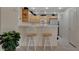 Well-lit kitchen with a breakfast bar, matching bar stools, and natural wood cabinets at 908 Domnus Ln # 203, Las Vegas, NV 89144