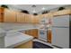Well-lit kitchen featuring white countertops, wooden cabinets, and essential appliances for a functional cooking space at 908 Domnus Ln # 203, Las Vegas, NV 89144
