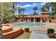 Inviting community pool with a patio area, palm trees, and comfortable seating for residents at 908 Domnus Ln # 203, Las Vegas, NV 89144