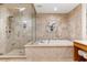 A bathroom features travertine floors and walls, a glass shower, and a soaking tub at 9101 Alta Dr # 205, Las Vegas, NV 89145