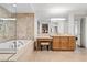 This spacious bathroom has travertine floors, a soaking tub, vanity area, and large mirror at 9101 Alta Dr # 205, Las Vegas, NV 89145