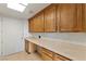Well-lit laundry room featuring ample cabinet storage and a long countertop for folding and organization at 9101 Alta Dr # 205, Las Vegas, NV 89145