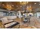Open lounge area with comfortable seating, chandeliers, stone columns, and decorative carpet at 9101 Alta Dr # 205, Las Vegas, NV 89145