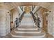 Elegant staircase featuring marble steps, decorative iron railings, and stone archways, showcasing exquisite design at 9101 Alta Dr # 205, Las Vegas, NV 89145