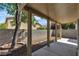 Back patio with concrete slab, brick wall, tree, and natural light offers outdoor relaxation at 9526 Vast Valley Ave, Las Vegas, NV 89148