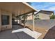 Covered patio has tan support beams, a concrete foundation, and gravel, providing a private backyard space at 9526 Vast Valley Ave, Las Vegas, NV 89148