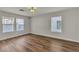 Bright bedroom with wood-look floors, two windows, and neutral wall colors at 9526 Vast Valley Ave, Las Vegas, NV 89148
