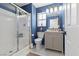 Modern bathroom with white tile shower, blue accent wall and stylish vanity cabinet at 9555 Belle Fountain Ave, Las Vegas, NV 89123