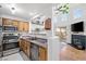 Well-lit kitchen boasting stainless steel appliances, wooden cabinets, and a pass-through to the living area at 9555 Belle Fountain Ave, Las Vegas, NV 89123