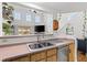 Kitchen pass-through with double sink, wood cabinets, and view of the living area's fireplace at 9555 Belle Fountain Ave, Las Vegas, NV 89123
