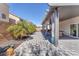 Inviting covered back patio features stylish pavers, privacy curtains, and lush landscaping at 9783 Hawk Crest St, Las Vegas, NV 89141