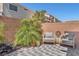 Private backyard patio features a charming seating area, brick fence and manicured landscaping at 9783 Hawk Crest St, Las Vegas, NV 89141