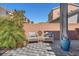 Private backyard patio features a charming seating area, brick fence and manicured landscaping at 9783 Hawk Crest St, Las Vegas, NV 89141