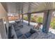 Relaxing covered backyard patio includes outdoor furniture, manicured landscaping, and privacy curtains at 9783 Hawk Crest St, Las Vegas, NV 89141