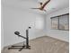 Bedroom with carpet features a ceiling fan, large window, and exercise equipment at 9783 Hawk Crest St, Las Vegas, NV 89141