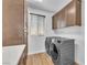 Laundry room with cabinets, countertop, stacked washer and dryer, and wood-look flooring at 9783 Hawk Crest St, Las Vegas, NV 89141