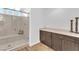 Elegant primary bathroom featuring a glass-enclosed shower with bench and neutral cabinetry at 9783 Hawk Crest St, Las Vegas, NV 89141