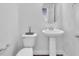 A clean and simple powder room with a pedestal sink, toilet, and neutral decor, creating a fresh look at 9783 Hawk Crest St, Las Vegas, NV 89141