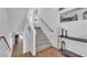 Bright staircase with neutral carpet, white risers, and dark wood handrail, leading to the upper level at 9783 Hawk Crest St, Las Vegas, NV 89141