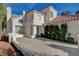 Charming two-story home featuring a red tile roof and lush front yard landscaping at 2864 Cape Verde Ln, Las Vegas, NV 89128