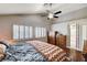 Main bedroom boasts hardwood floors, a ceiling fan, and natural light from shuttered windows at 2864 Cape Verde Ln, Las Vegas, NV 89128