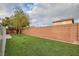 Backyard with artificial grass, block wall, and a wooden playhouse at 10632 Open Range Ct, Las Vegas, NV 89179