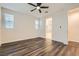 A bedroom with wood floors, white walls, window blinds, and a view of the bathroom at 10632 Open Range Ct, Las Vegas, NV 89179