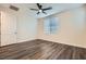 A bedroom with dark wood floors, window blinds, white walls, and a ceiling fan at 10632 Open Range Ct, Las Vegas, NV 89179