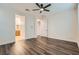 A bedroom with dark wood floors, white walls, and a view of the bathroom at 10632 Open Range Ct, Las Vegas, NV 89179