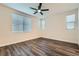 A bedroom with wood floors, a ceiling fan, white walls, and window blinds at 10632 Open Range Ct, Las Vegas, NV 89179