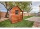 Backyard wooden playhouse on artificial grass with stone and brick details at 10632 Open Range Ct, Las Vegas, NV 89179