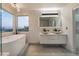 Spa-like bathroom featuring double vanities, a soaking tub, and contemporary fixtures at 1168 Spago Ln, Henderson, NV 89052