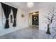 Bright living room with a decorative chandelier, gray tile flooring and dark decorative accents at 1168 Spago Ln, Henderson, NV 89052