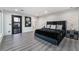 Modern main bedroom features sleek design with hardwood floors, stylish lighting and a luxurious black upholstered bed set at 1168 Spago Ln, Henderson, NV 89052