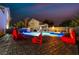 Outdoor pool with dynamic lighting, artistic statues, and plush lounge seating, perfect for nighttime relaxation at 1168 Spago Ln, Henderson, NV 89052