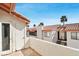 Balcony view of adjacent townhomes with red tile roofs and palm trees set against a bright blue sky at 1701 E Katie Ave # 36, Las Vegas, NV 89119