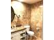 Bathroom with granite countertops, decorative mirror and travertine tile at 30 Strada Di Villaggio # 118, Henderson, NV 89011