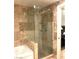 Bathroom with glass shower door, travertine tile and built in shower shelving, next to the bathtub at 30 Strada Di Villaggio # 118, Henderson, NV 89011