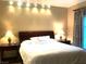 Bedroom with neutral colored walls and bedding with dark wood furniture and decorative lighting at 30 Strada Di Villaggio # 118, Henderson, NV 89011