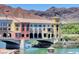 Beautiful exterior view of a lakeside building on a bridge, surrounded by mountains and lush greenery at 30 Strada Di Villaggio # 118, Henderson, NV 89011