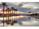Reflective community pond at sunset with mature palms and mountain backdrop at 30 Strada Di Villaggio # 118, Henderson, NV 89011