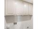 Clean, white cabinets with modern hardware offer ample storage space above a utility area with outlets and plumbing connections at 3021 Ocean Port Dr, Las Vegas, NV 89117