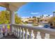 Balcony view of suburban street with well-maintained homes, green lawns, and mature palm trees under a clear blue sky at 3021 Ocean Port Dr, Las Vegas, NV 89117