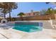 Inviting pool with fireplace, palm trees, steps, and brick privacy wall at 3021 Ocean Port Dr, Las Vegas, NV 89117