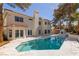 Expansive pool and spa with a built-in fireplace, complemented by a stucco home exterior at 3021 Ocean Port Dr, Las Vegas, NV 89117